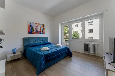 a bedroom with a blue bed and a window at Vatican Suite Apartament Roma in Rome