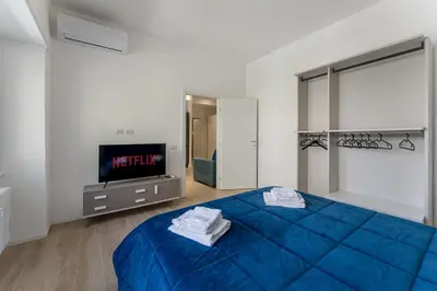 a bedroom with a blue bed and a tv at Vatican Suite Apartament Roma in Rome