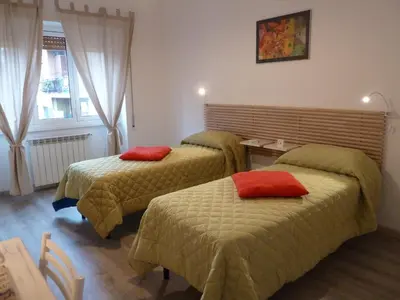 two beds in a hotel room with red pillows on them at Stesi Vacanze in Rome