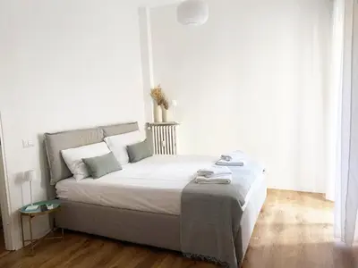 a bedroom with a bed with white walls and wooden floors at Germanico Apartments in Rome