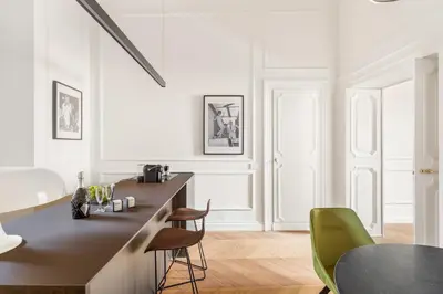 a white kitchen with a counter and chairs at Charm and Elegance by The Spanish Steps in Rome