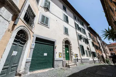 a building with two green doors on a street at FRAM Apartment Fori Imperiali in Rome