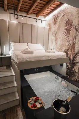 a bedroom with a bed and a bowl of fruit on a table at Suite del Grillo - Fori Imperiali - Il Nido d'Amore in Rome
