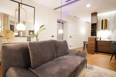 a living room with a couch and a kitchen at Suite del Grillo - Fori Imperiali - Il Nido d'Amore in Rome