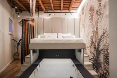a bedroom with a bed in the middle of a room at Suite del Grillo - Fori Imperiali - Il Nido d'Amore in Rome