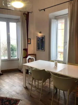 a white table and chairs in a room with windows at Large apartment in Rome city center in Rome