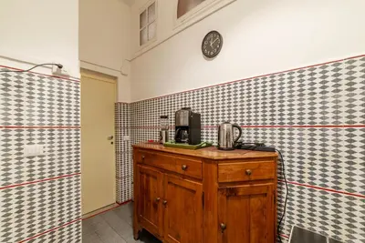 a kitchen with a wooden cabinet and a clock on the wall at GuestHost - Pantheon Apartment - L'angolo nascosto dei quadri in Rome