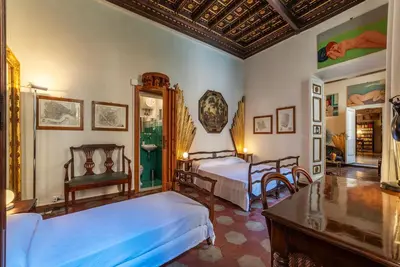 a bedroom with two beds and a table at GuestHost - Pantheon Apartment - L'angolo nascosto dei quadri in Rome