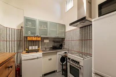 a kitchen with white cabinets and a stove top oven at GuestHost - Pantheon Apartment - L'angolo nascosto dei quadri in Rome