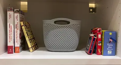 a shelf with a vase and books on it at M&M Pigneto Roma in Rome