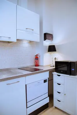 a kitchen with white cabinets and a microwave at Casa Donna Olimpia Appartamento Roma in Rome