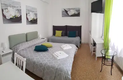 a small room with two beds and a desk at Rose Antiche Vatican B&B in Rome