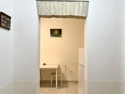a small kitchen with a table and a refrigerator at Vaticano - 5 min da stazione in Rome