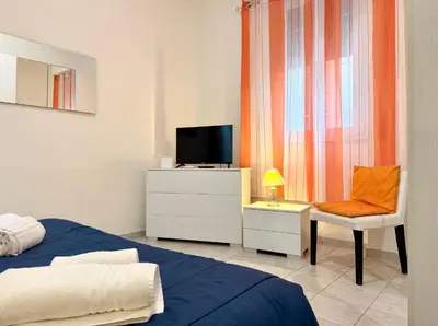 a bedroom with a bed and a tv and a chair at Vaticano - 5 min da stazione in Rome