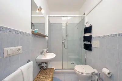 a bathroom with a shower and a toilet and a sink at Cozy Merulana in Rome