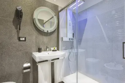 a bathroom with a sink and a shower with a mirror at Excellence Suite in Rome