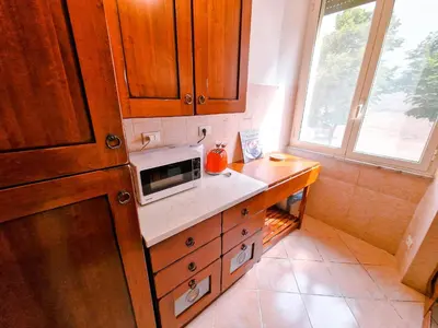 a kitchen with wooden cabinets and a microwave on a counter at Vatican Shelter in Rome