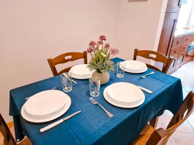 a blue table with plates and a vase of flowers on it at Vatican Shelter in Rome