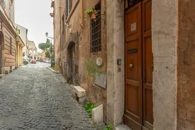 an alley with a brown door on the side of a building at Colosseum house in Rome
