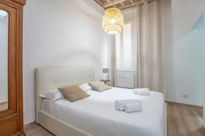 a bedroom with a white bed with two towels on it at Colosseum house in Rome