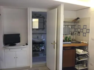 a kitchen with a sink and a tv in a room at Trastevere onlyone in Rome