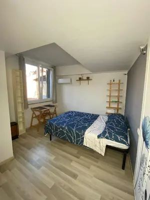 a bedroom with a bed with a blue comforter and a window at Trastevere onlyone in Rome