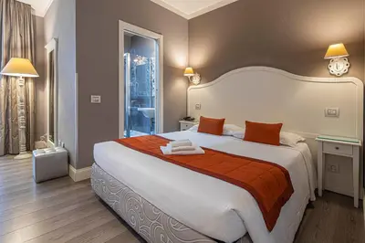 a bedroom with a large bed with orange and white sheets at Residenza Castrense in Rome