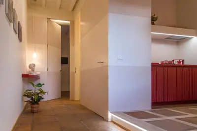 a hallway with white walls and a plant at La Porta Rossa di Borgo - Vatican Luxury Suite in Rome