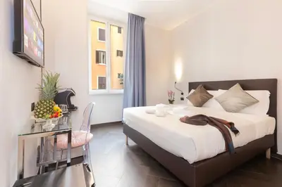 a bedroom with a bed and a table and a television at Cloud 9 Hotel in Rome