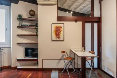 a room with a table and chairs and a staircase at GuestHost - Piazza Navona Petite House in Rome