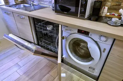 a washing machine in a kitchen with a microwave at Marigiò Vatican Apartment in Rome