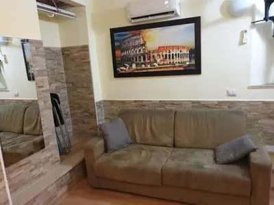 a living room with a couch and a painting on the wall at Holiday City Centre in Rome