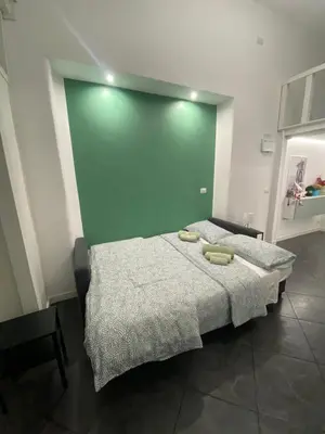 a bedroom with a bed with a green wall at Loft Torlonia in Rome