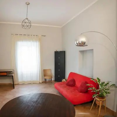 a living room with a red couch and a table at Obiettivo Roma in Rome