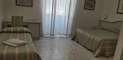 a bedroom with two beds and a table and a desk at Gioia Guest House in Rome