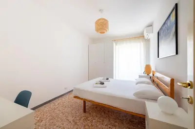 a white bedroom with a bed and a window at Casa Tripolitania in Rome
