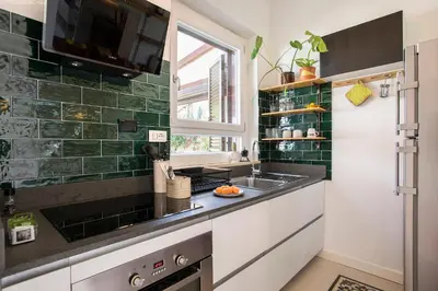 a kitchen with a sink and green tiles at Giardino al 9 in Rome