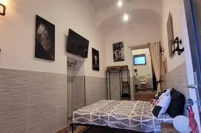 a bedroom with a bed and a tv on the wall at Trastevere Home Gallery in Rome