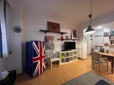 a living room with a blue refrigerator and a table at 2 Bedroom Flat at just 4 tube stops from Coliseum in Rome