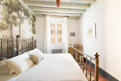 a bedroom with a bed and a painting on the wall at Charming Design Apartment in Monti in Rome