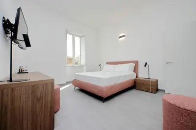 a bedroom with a bed and a flat screen tv at Youroom Monteverde - Rooms in Rome