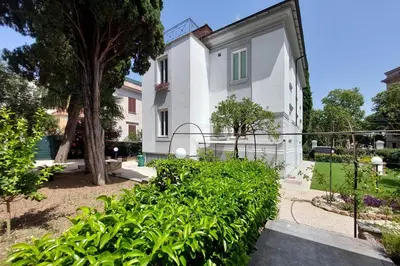 a white house with a fence and plants at Youroom Monteverde - Rooms in Rome