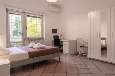 a bedroom with a bed and a desk and a chair at Roma SanPaolo Apartment in Rome