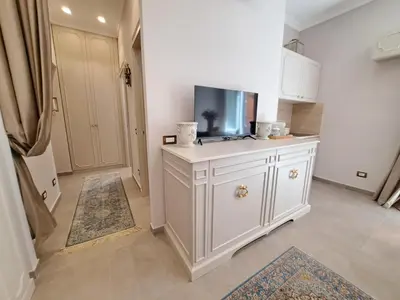 a kitchen with a white cabinet with a tv on it at Suite della Vite 27 in Rome
