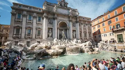 a crowd of people standing around a fountain in front of a building at Suite della Vite 27 in Rome