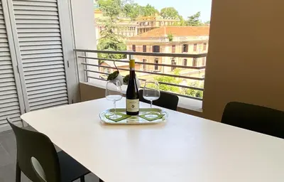 a bottle of wine on a white table with a window at Olmocolmo Trastevere in Rome