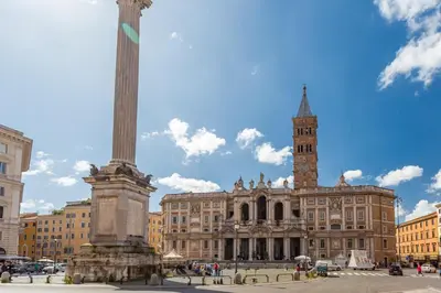 a large building with a tall column and a clock tower at Oscar Apt near Landmarks and Colosseum in Rome