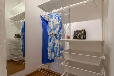 a walk in closet with blue curtains and shelves at Minerva - Elegant New Classic close to Vatican in Rome