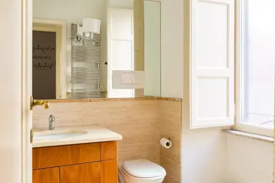 a bathroom with a sink and a toilet and a mirror at Holiday Room Naiadis in Rome