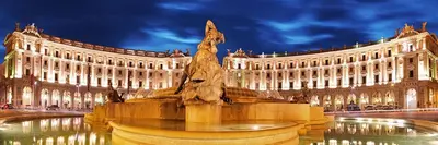 a statue in front of a large building at night at Holiday Room Naiadis in Rome